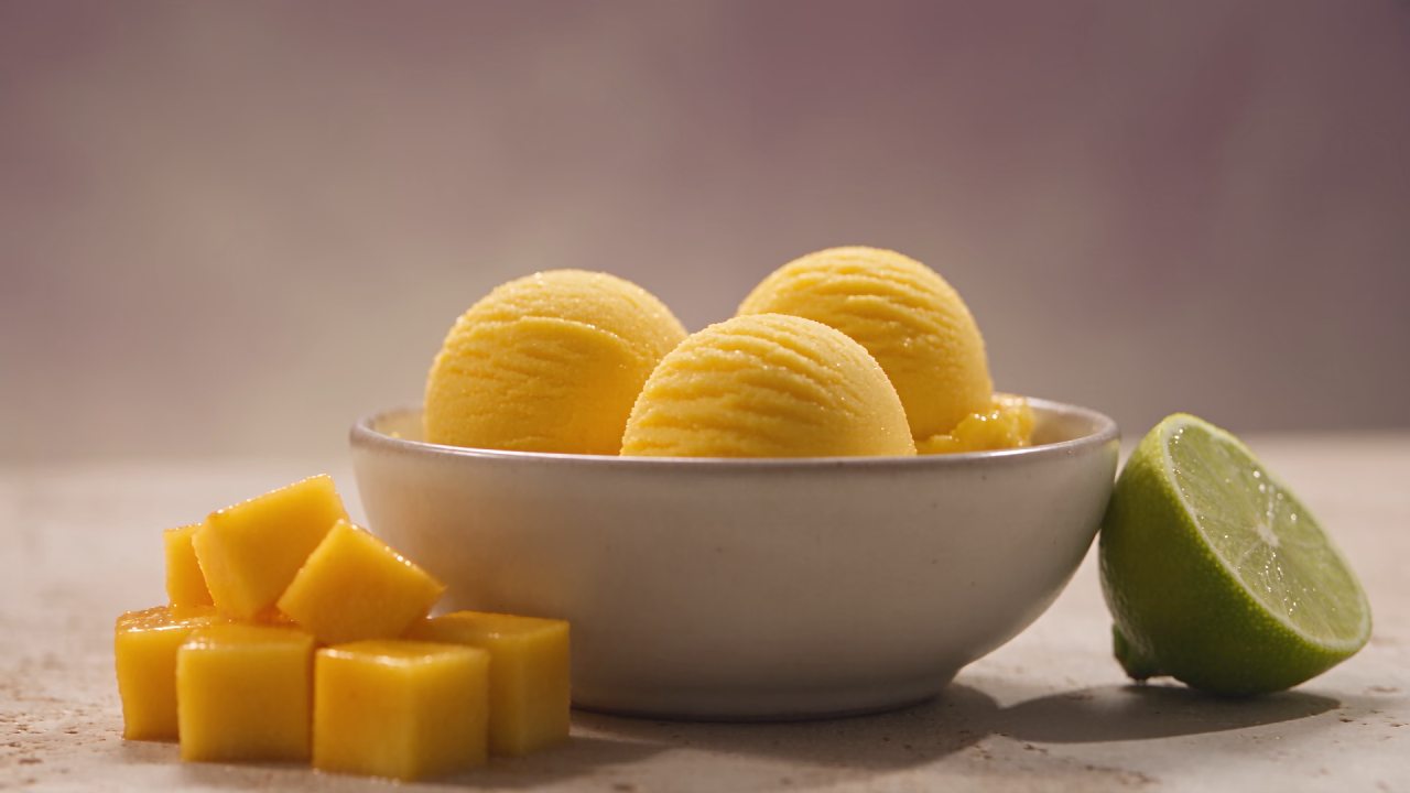 Zlate kepice mangovega sorbeta s svežim mangom in limeto.